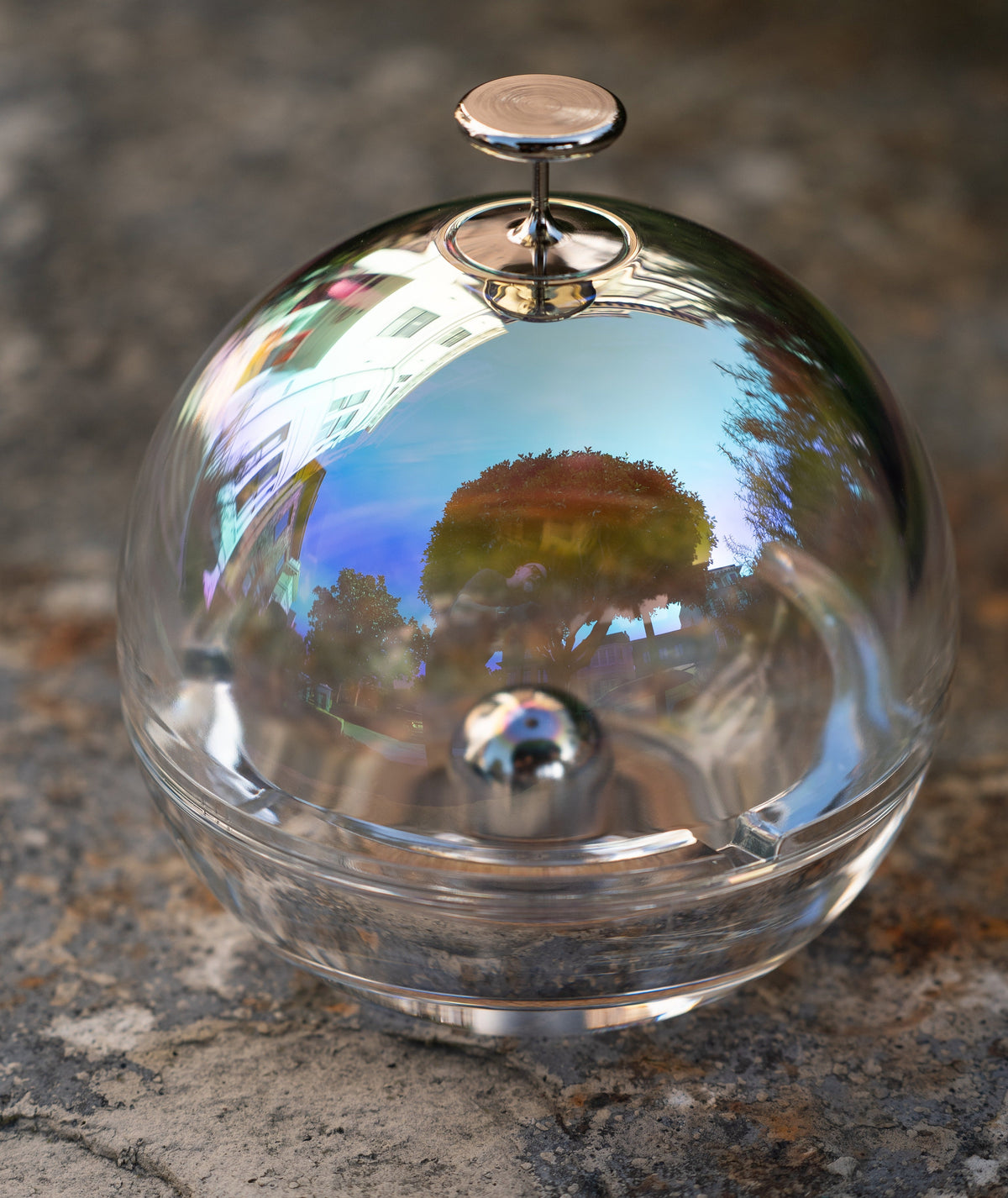 The dichroic-coated dome of Murmmr's Close Magic ashtray, catching a reflection of a tree and sky