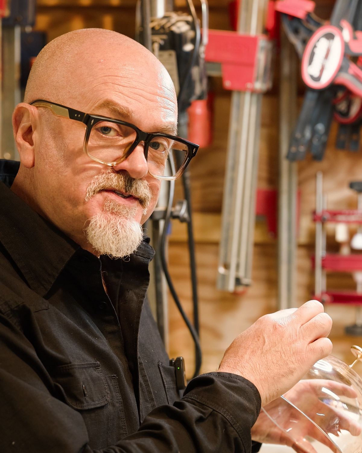 Greg at the bench holding the crystal dome by its brass handle